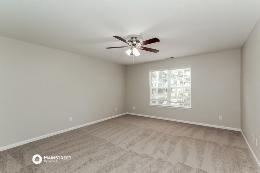 the spacious living room with ceiling fan and vinyl flooring