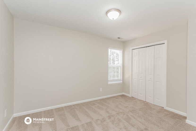 the spacious living room with a door to the bedroom