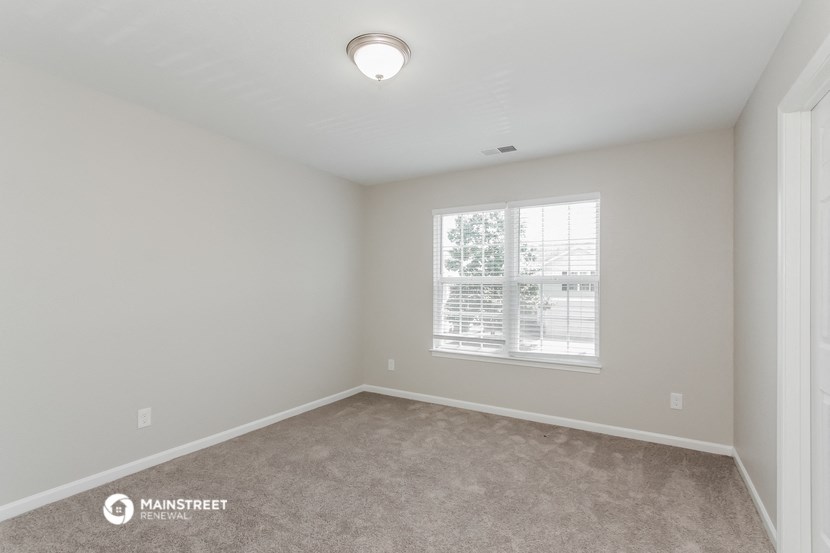 a bedroom with a carpeted floor and a window