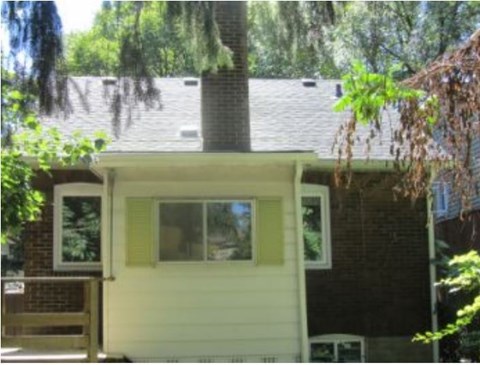 a small house with a window and a tree