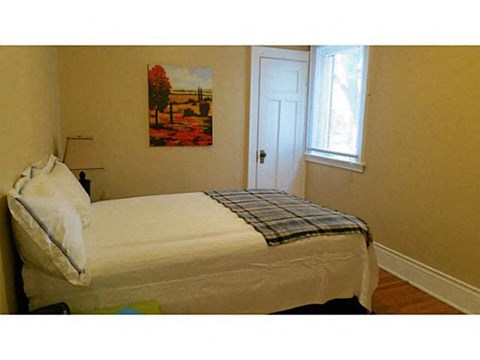 a small bedroom with a bed and a window