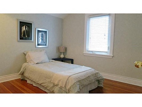 a small bedroom with a bed and a window