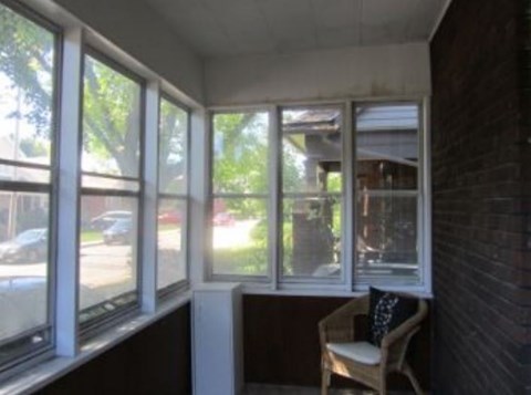 a living room with a bunch of windows and a chair