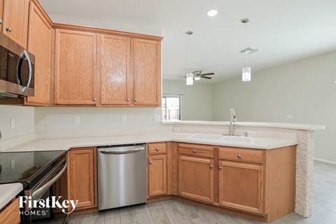 A kitchen with wooden cabinets and a stainless steel dishwasher.