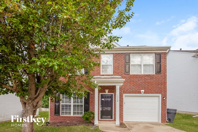 a brick house with a tree in front of it