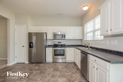 a kitchen with stainless steel appliances and white cabinets