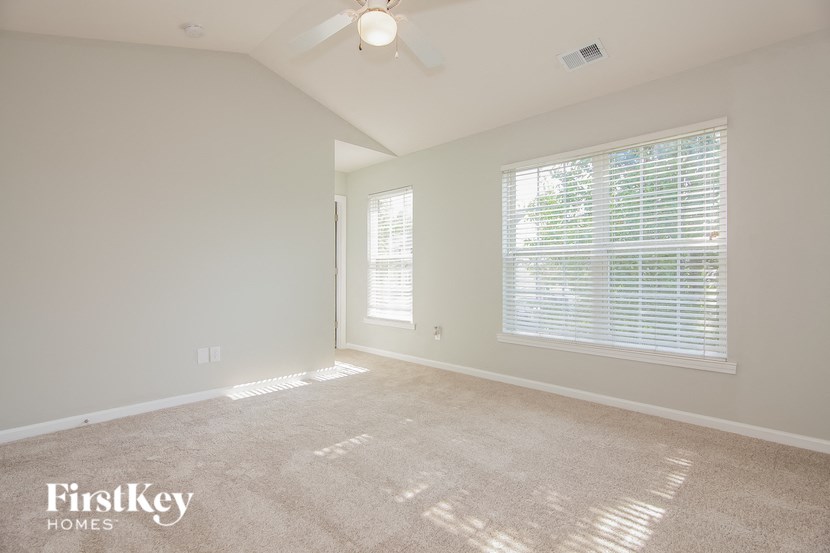 an empty room with a large window and a ceiling fan