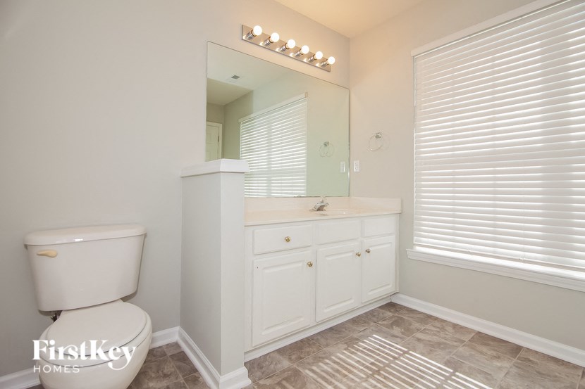 a bathroom with a toilet and a sink and a mirror