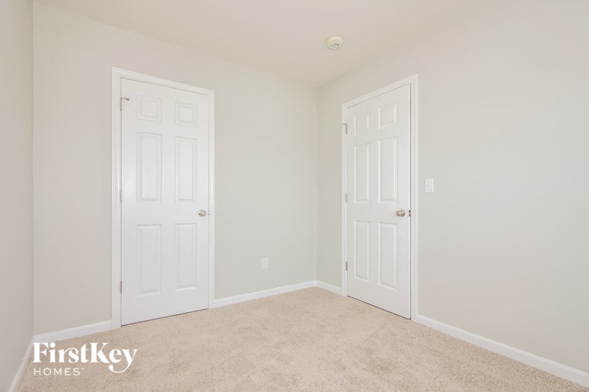 a bedroom with two white doors and a carpeted floor