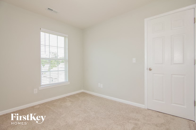 a bedroom with a white door and a window