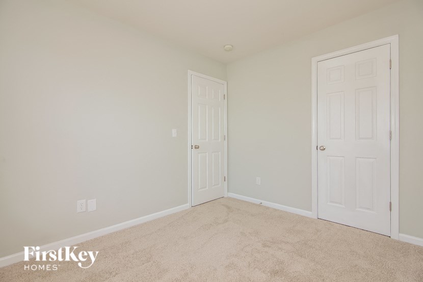 a bedroom with two doors and a carpeted floor