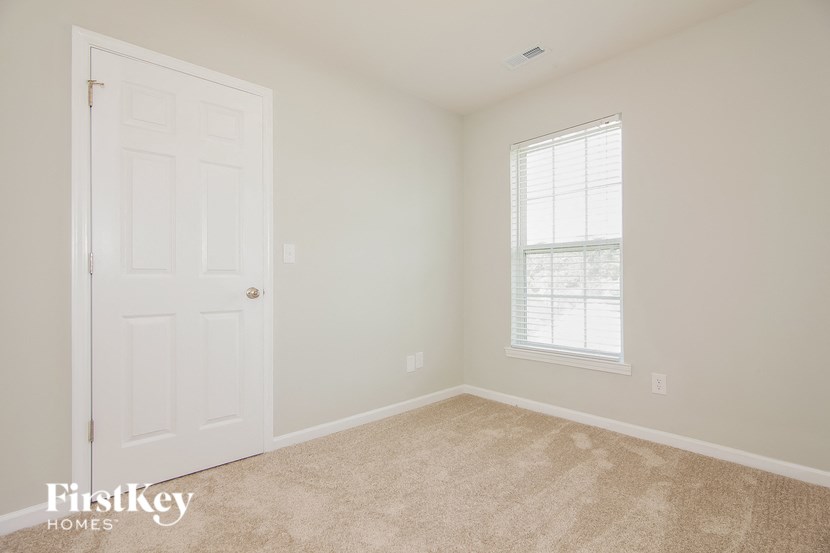 a bedroom with a white door and a window
