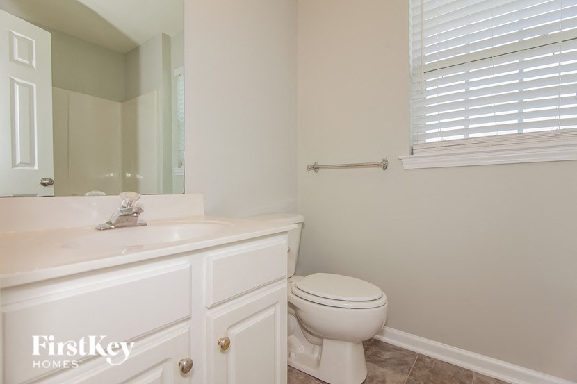 a bathroom with a toilet and a sink and a mirror