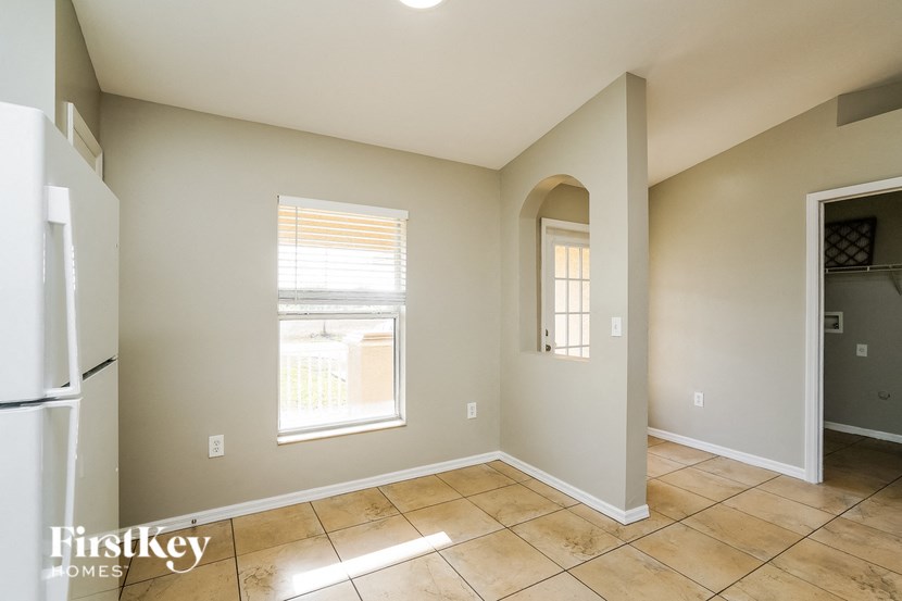 an empty room with a refrigerator and a window