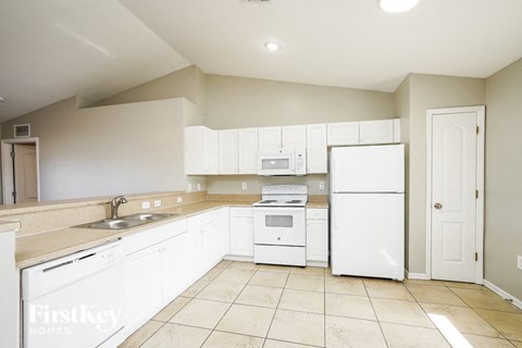 a large kitchen with white appliances and white cabinets