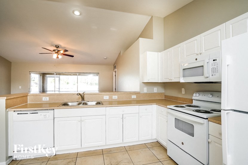 a large kitchen with white appliances and white cabinets