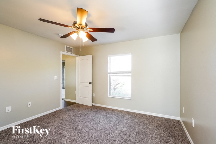 a bedroom with a ceiling fan and a window