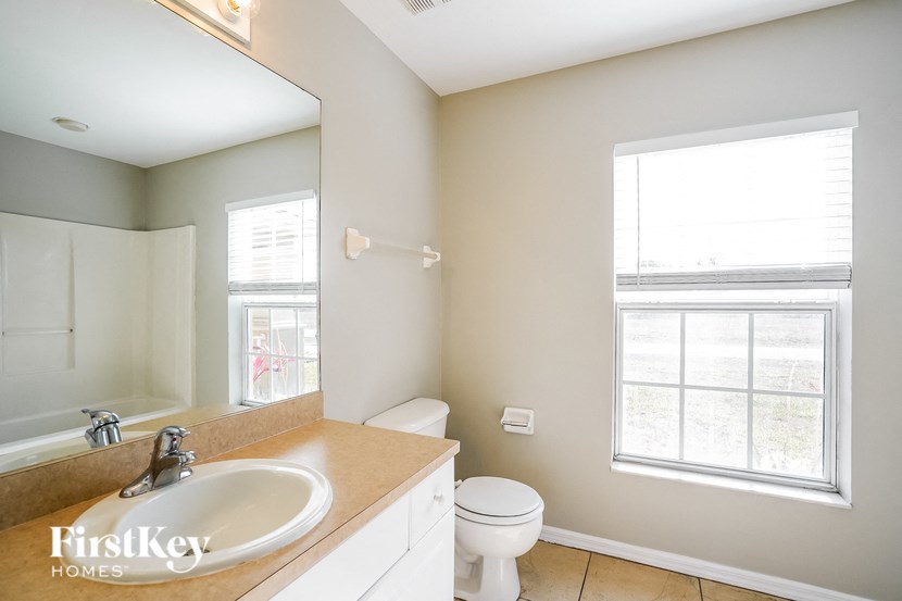 a bathroom with a toilet and a sink and a mirror