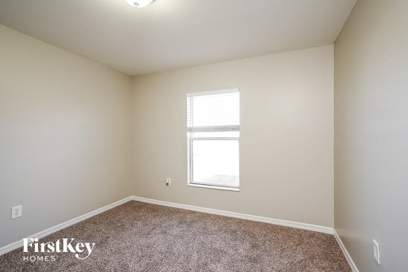 an empty room with a window and carpet