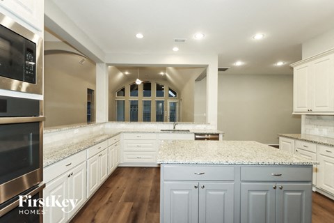 a large kitchen with white cabinets and white counter tops