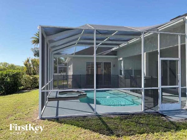 a glass house with a pool on the grass