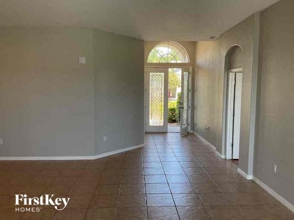 a large empty living room with a tile floor