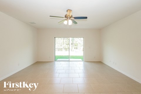 a empty living room with a ceiling fan
