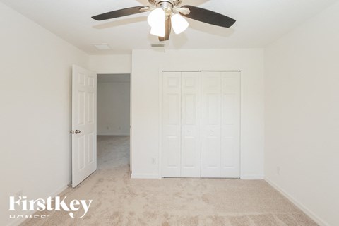 a bedroom with a ceiling fan and a closet