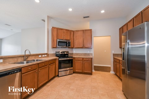 a kitchen with wooden cabinets and stainless steel appliances