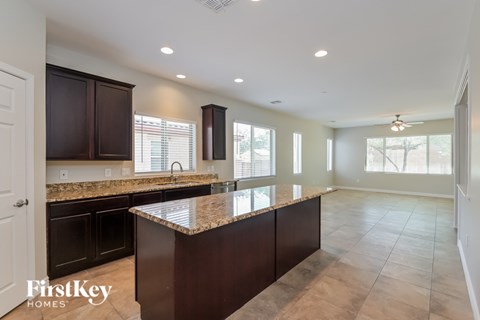 A kitchen with brown cabinets and a granite countertop.