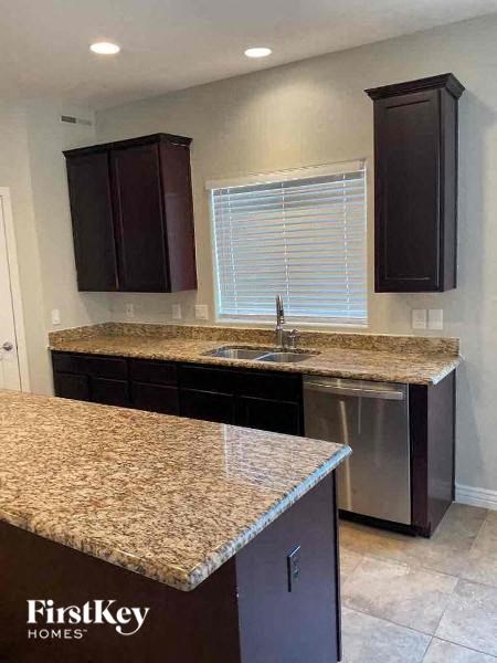 a kitchen with granite counter tops and dark cabinets