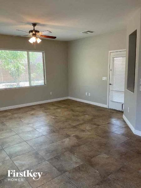 an empty living room with a ceiling fan