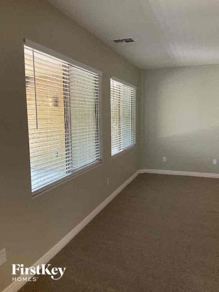 an empty living room with three large windows