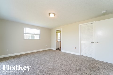 a bedroom with carpet and a door to a bathroom