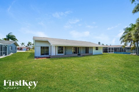 a house with a large grassy yard and a pool