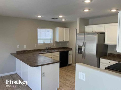 a kitchen with white cabinets and a stainless steel refrigerator