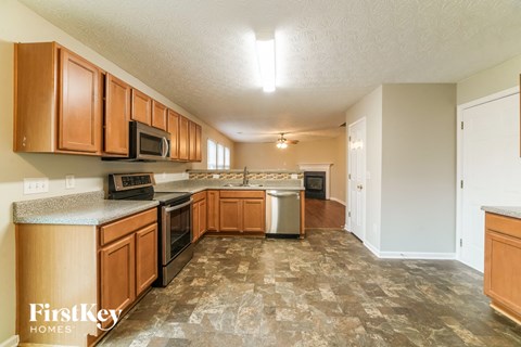 A kitchen with wooden cabinets and a tiled floor.