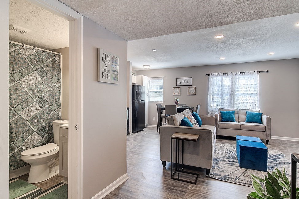 a living room and bathroom with a toilet and a couch