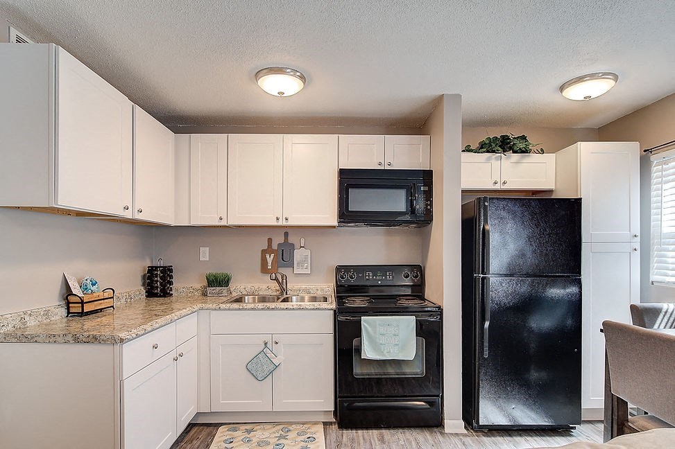 a kitchen with black appliances and white cabinets