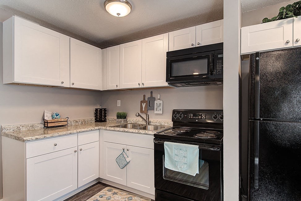 a kitchen with black appliances and white cabinets