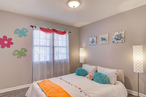 a bedroom with a bed and some paintings on the wall