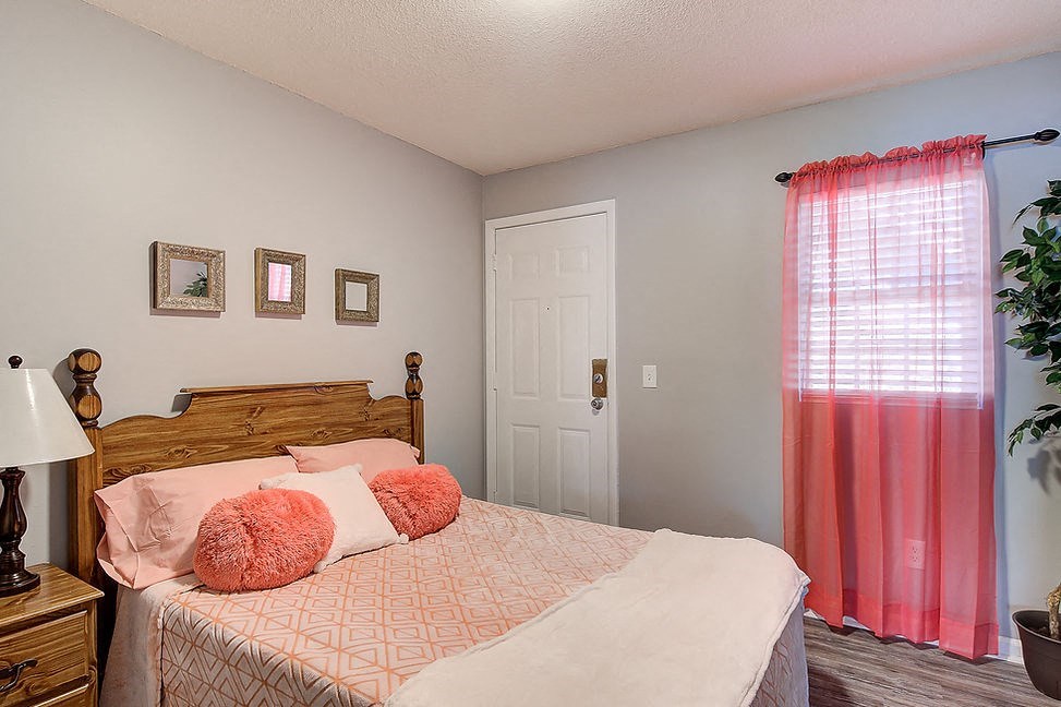a bedroom with a bed with pink pillows