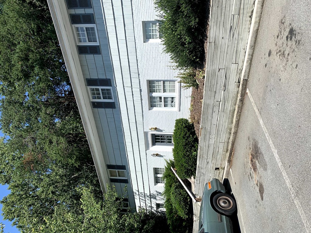 an aerial view of an apartment building with a car parked in the street