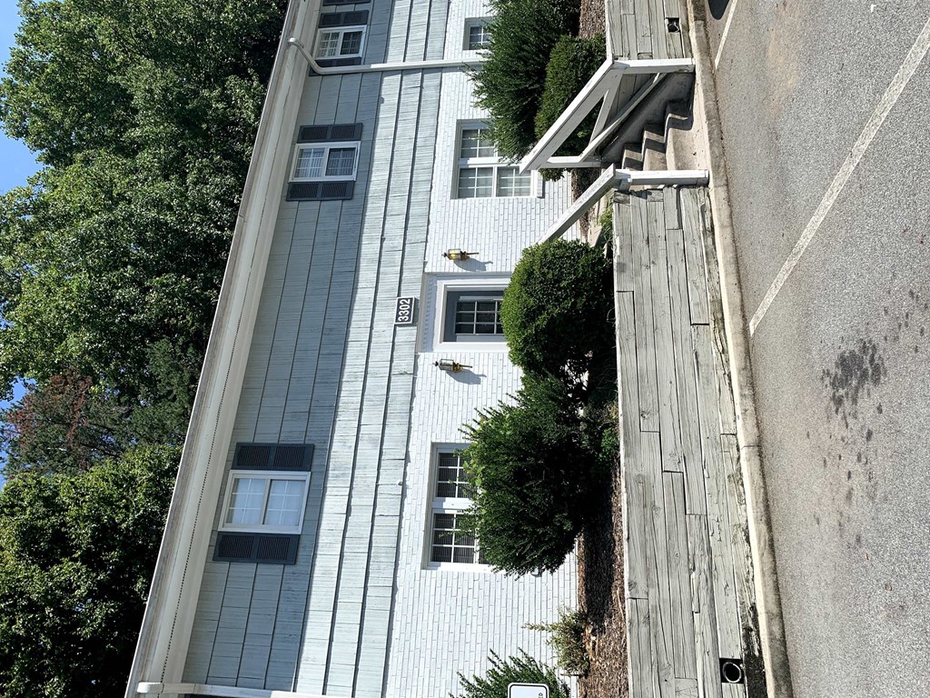 an aerial view of a tall white building with trees