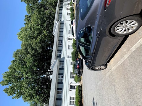 a car driving down a street next to a tall building