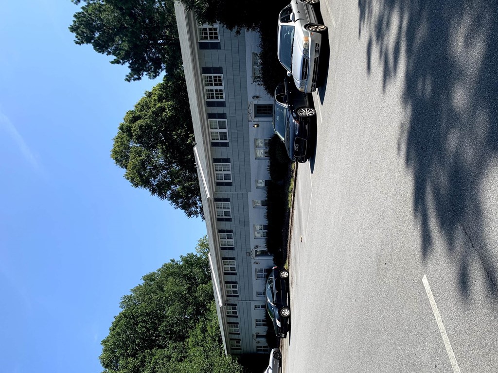 a car driving down a street next to a tall building