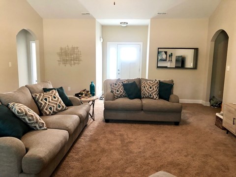 A living room with two couches and a rug.