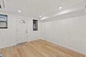 an empty living room with white walls and a wooden floor