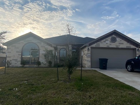 A house with a garage and a car parked in front.