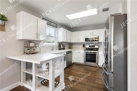 a modern kitchen with white cabinets and stainless steel appliances